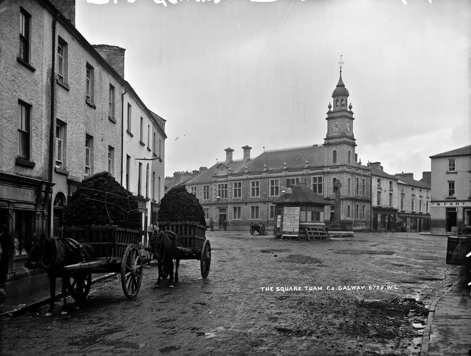 A historic photograph of people carrying cut turf home in creels